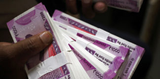 FILE PHOTO: A cashier displays the new 2000 Indian rupee banknotes inside a bank in Jammu